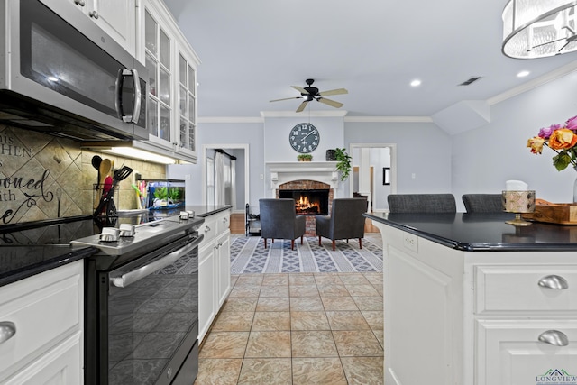 5201 Whitaker, Longview, TX 75605 - kitchen featuring appliances with stainless steel finishes, dark countertops, ceiling fan, tasteful backsplash, and ornamental molding