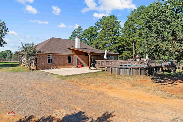 rear view of house with a pool side deck and a patio