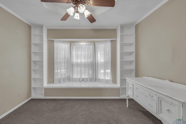 interior space with dark colored carpet, a textured ceiling, baseboards, ceiling fan, and crown molding