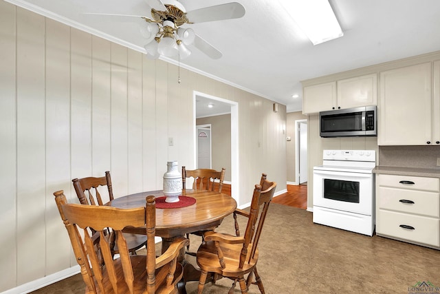 dining room with ceiling fan, baseboards, and crown molding