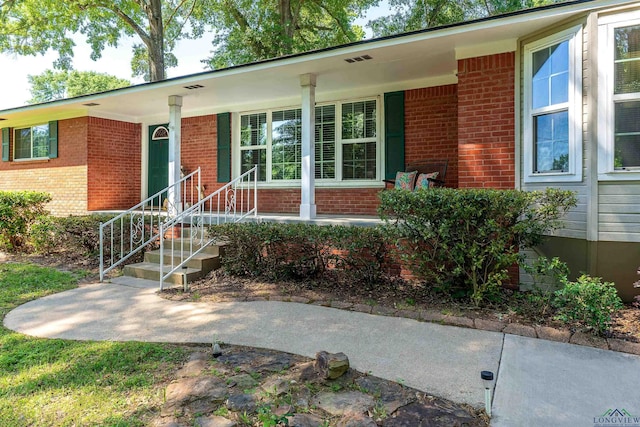 view of front of home with a porch and brick siding