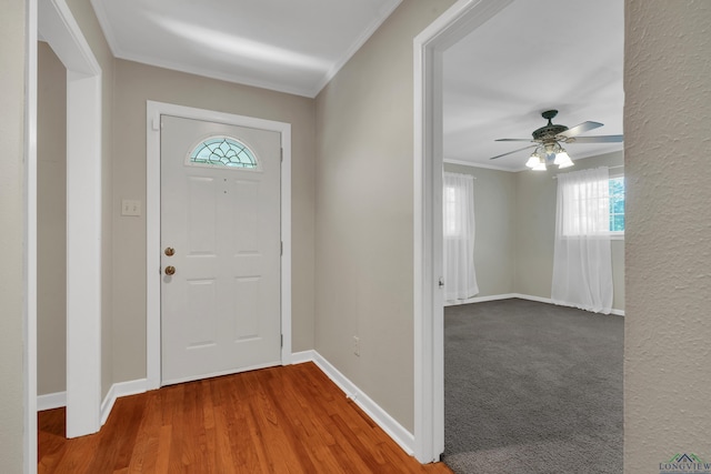 entryway featuring plenty of natural light, crown molding, baseboards, and ceiling fan