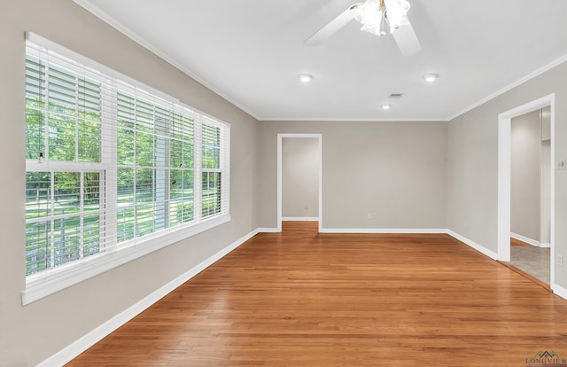 empty room featuring light wood-style flooring, crown molding, baseboards, and ceiling fan