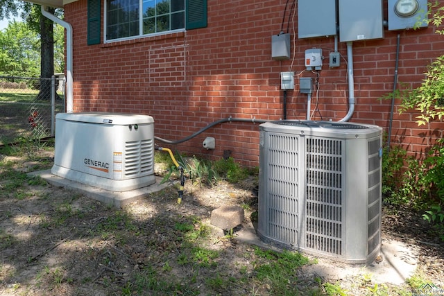 exterior details with a power unit, electric meter, brick siding, and central air condition unit