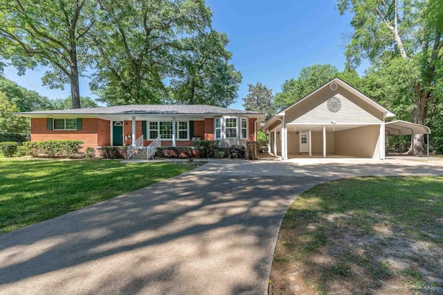 single story home with driveway, covered porch, a carport, brick siding, and a front yard