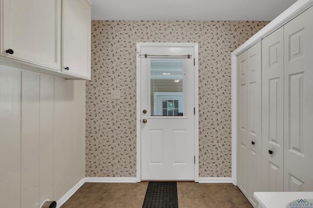 mudroom with wallpapered walls, baseboards, and dark carpet