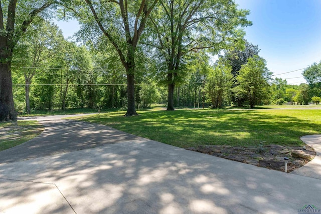 view of property's community with a forest view and a yard