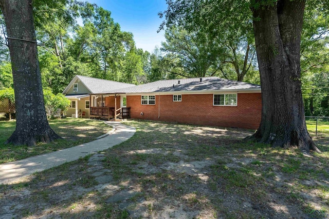 back of property featuring a porch and fence