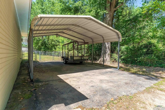 view of vehicle parking featuring a detached carport and fence