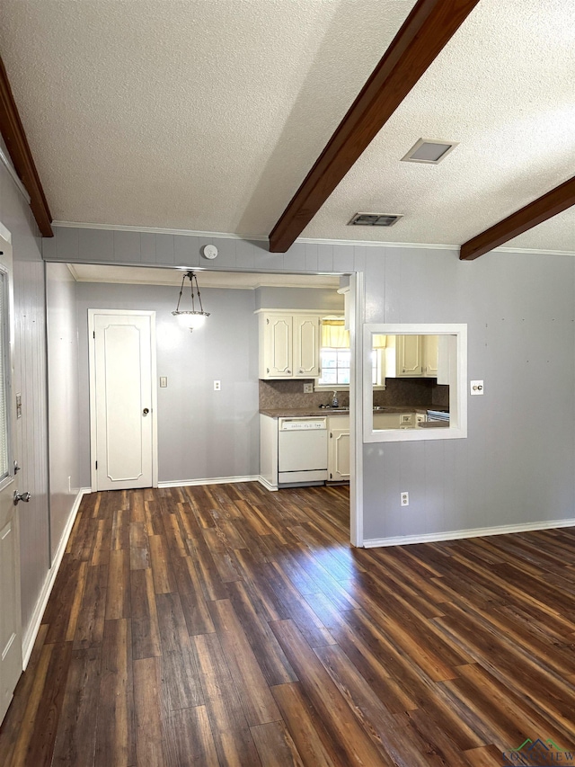 909 Stewart St, Atlanta, TX 75551 - unfurnished living room featuring a textured ceiling, dark wood-type flooring, beamed ceiling, and ornamental molding