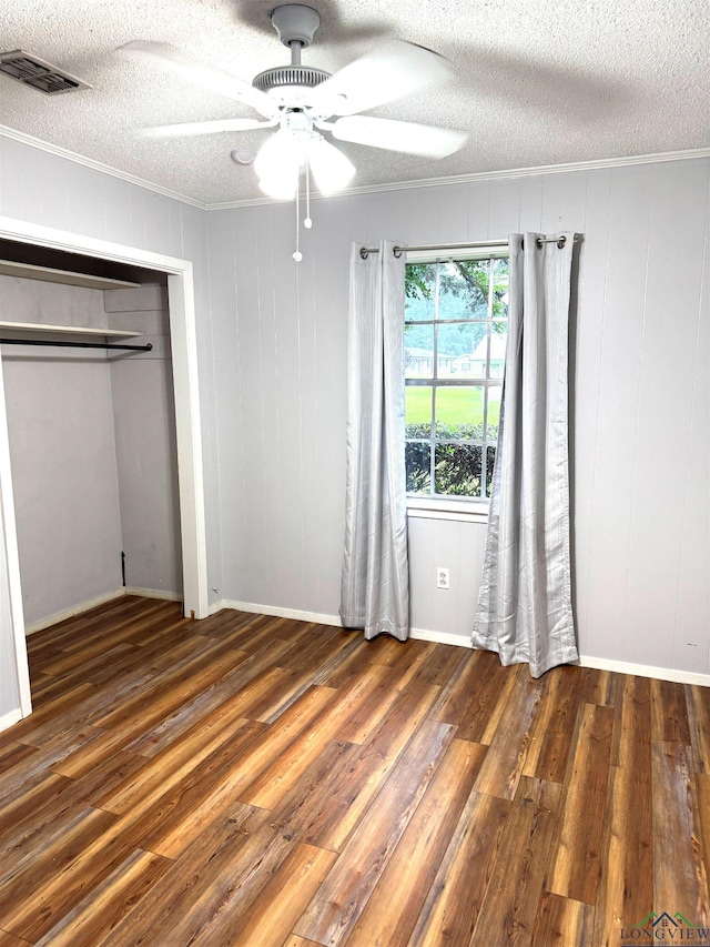 909 Stewart St, Atlanta, TX 75551 - unfurnished bedroom with a textured ceiling, wood finished floors, ornamental molding, ceiling fan, and a closet