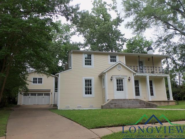 view of front of house featuring a balcony, a garage, and a front lawn