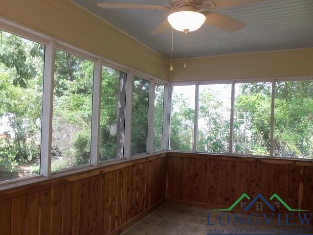 unfurnished sunroom featuring ceiling fan