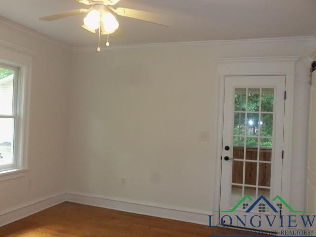 empty room featuring ceiling fan, ornamental molding, and hardwood / wood-style flooring