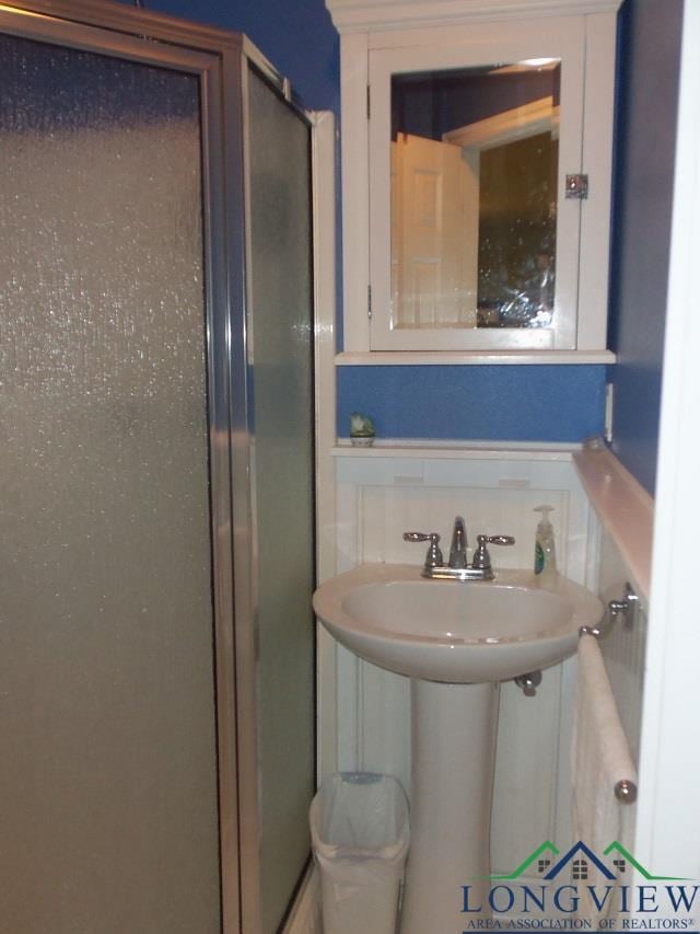 bathroom with a shower with shower door and tasteful backsplash