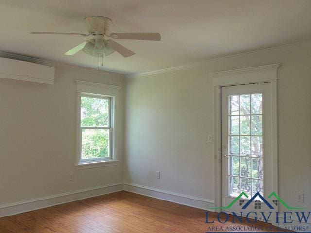 unfurnished room with a wall mounted air conditioner, light wood-type flooring, a wealth of natural light, and crown molding