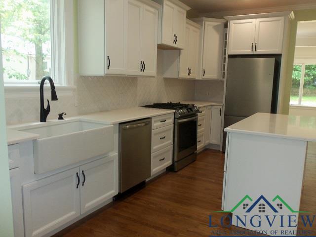 kitchen with decorative backsplash, appliances with stainless steel finishes, white cabinetry, and sink