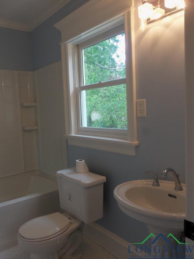 full bathroom with shower / bathing tub combination, toilet, ornamental molding, and sink