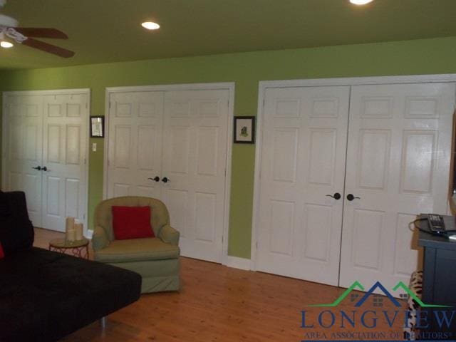 living area with ceiling fan and hardwood / wood-style flooring