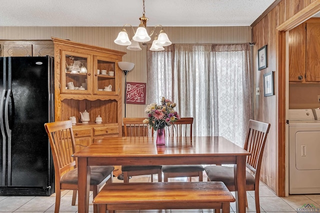dining space with a textured ceiling, a notable chandelier, and light tile patterned floors