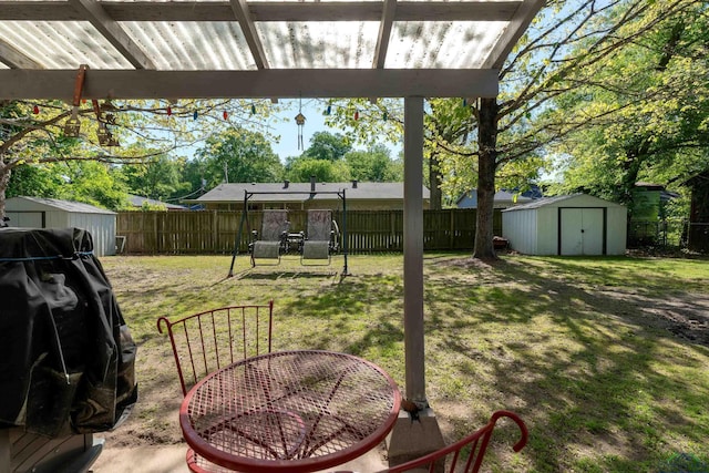 view of yard with a fenced backyard, an outbuilding, and a storage unit