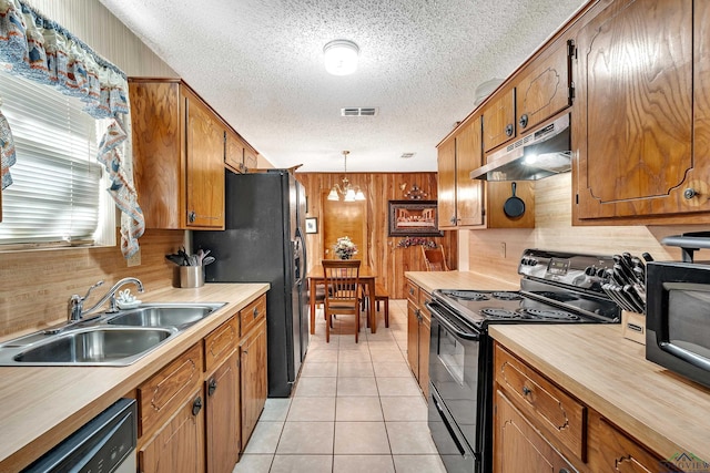 kitchen featuring black appliances, under cabinet range hood, a sink, and a textured ceiling