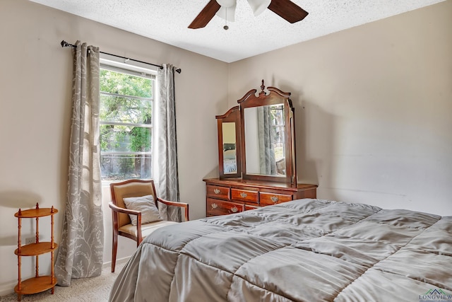 bedroom featuring carpet floors, a ceiling fan, and a textured ceiling