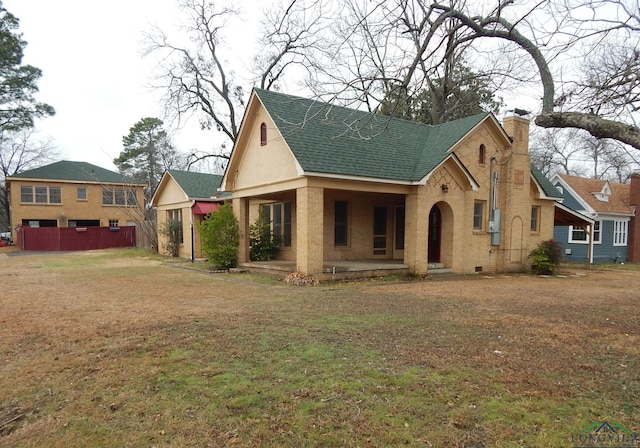 view of front of house with a front yard and a patio area