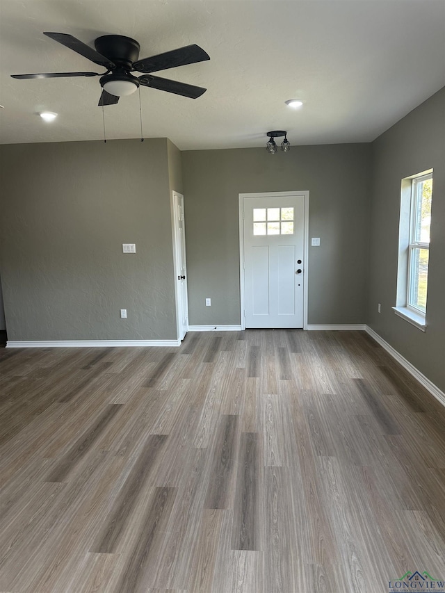 204 Alma St, Longview, TX 75605 - unfurnished living room with healthy amount of natural light, wood finished floors, ceiling fan, and baseboards
