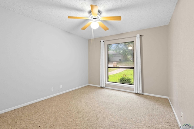 carpeted spare room featuring a textured ceiling, plenty of natural light, and ceiling fan