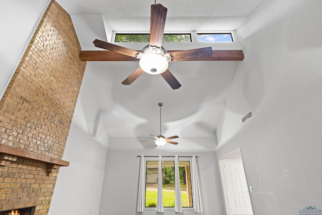 details with a textured ceiling, ceiling fan, and a fireplace