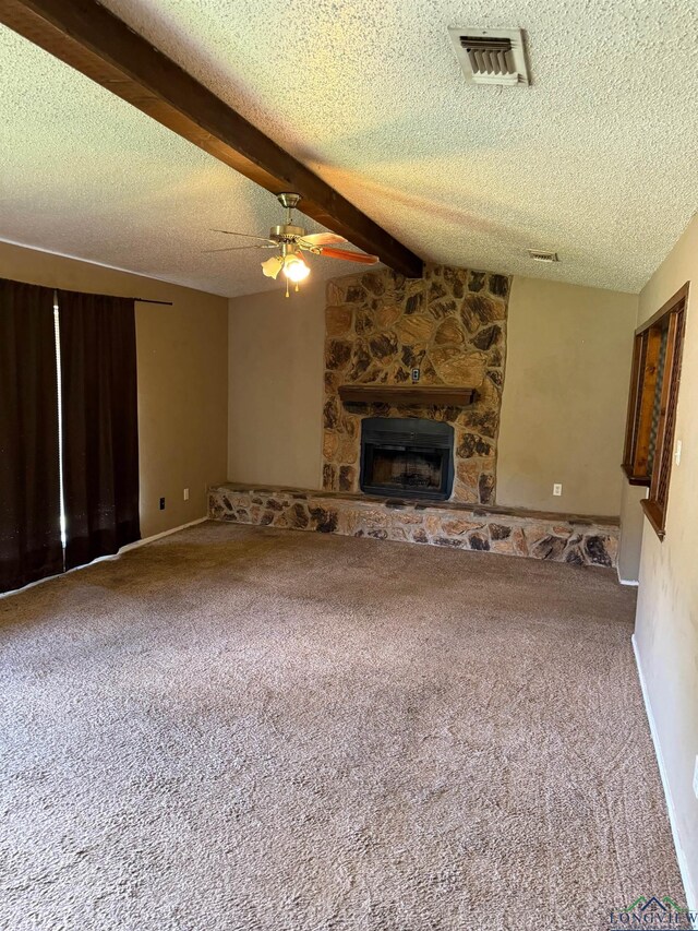 206 Syble Ln, Longview, TX 75605 - unfurnished living room featuring ceiling fan, a textured ceiling, a fireplace, carpet, and beamed ceiling