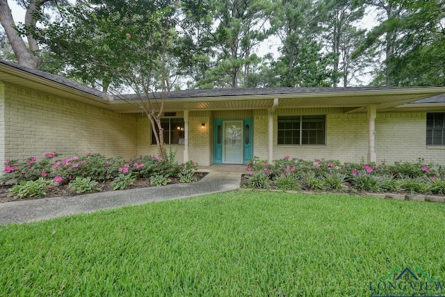 view of exterior entry with a lawn