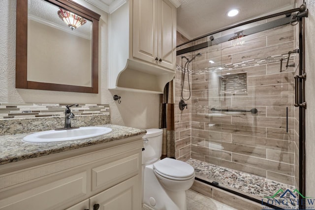 bathroom featuring a shower with door, ornamental molding, vanity, and toilet