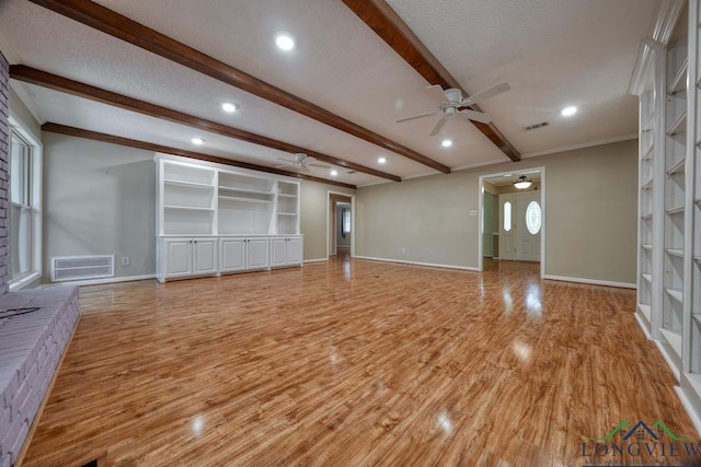 unfurnished living room featuring light hardwood / wood-style flooring, built in features, ceiling fan, a textured ceiling, and beamed ceiling