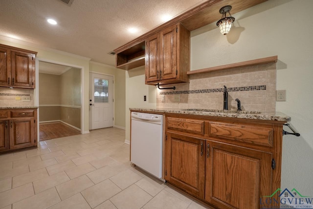 kitchen with sink, crown molding, dishwasher, light stone countertops, and decorative backsplash