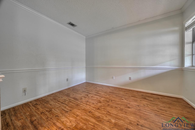 empty room with ornamental molding, wood-type flooring, and a textured ceiling