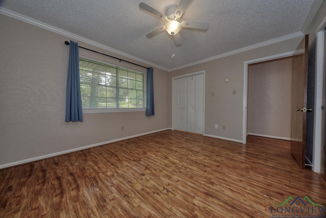 unfurnished bedroom with crown molding, wood-type flooring, a textured ceiling, a closet, and ceiling fan