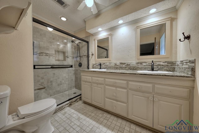 bathroom featuring crown molding, a shower with door, vanity, a textured ceiling, and toilet