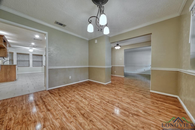 unfurnished room featuring ornamental molding, a textured ceiling, and light wood-type flooring