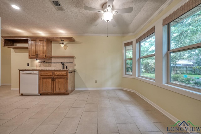 kitchen featuring light stone countertops, a healthy amount of sunlight, light tile patterned floors, and white dishwasher