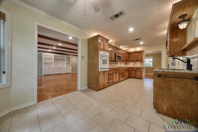 kitchen featuring sink, white oven, light stone countertops, a textured ceiling, and light tile patterned flooring