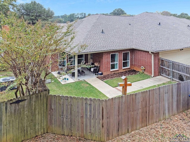 rear view of house featuring a lawn and a patio area