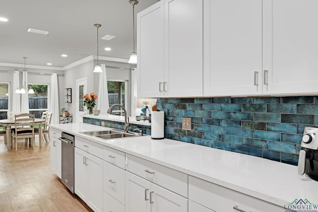 kitchen featuring sink, hanging light fixtures, tasteful backsplash, a healthy amount of sunlight, and white cabinetry