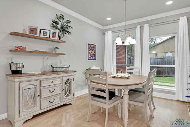 dining area featuring a chandelier, light hardwood / wood-style flooring, and crown molding