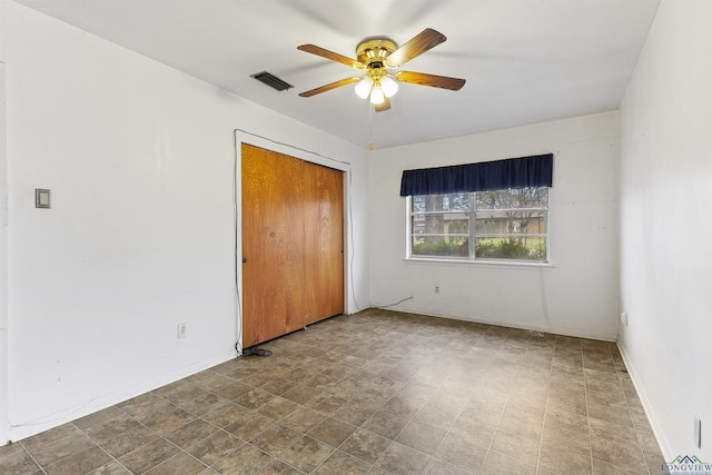 unfurnished bedroom featuring ceiling fan and a closet