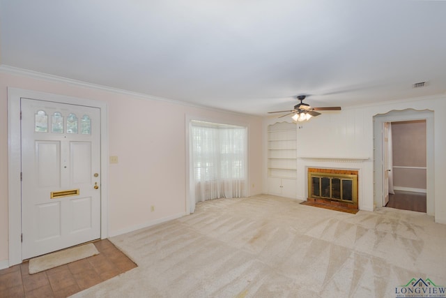 15 Rockwall Dr, Longview, TX 75604 - unfurnished living room with ornamental molding, ceiling fan, a fireplace with flush hearth, built in shelves, and carpet