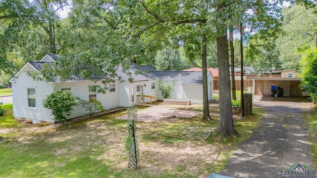 15 Rockwall Dr, Longview, TX 75604 - rear view of house featuring a shingled roof, view of scattered trees, and driveway