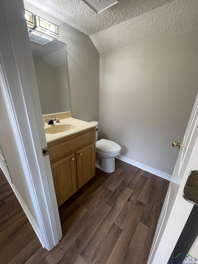 1206 Brandywine Dr, Longview, TX 75601 - half bath featuring a textured ceiling, vanity, wood finished floors, and lofted ceiling