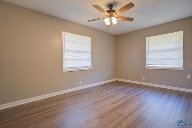 empty room with dark hardwood / wood-style floors and ceiling fan